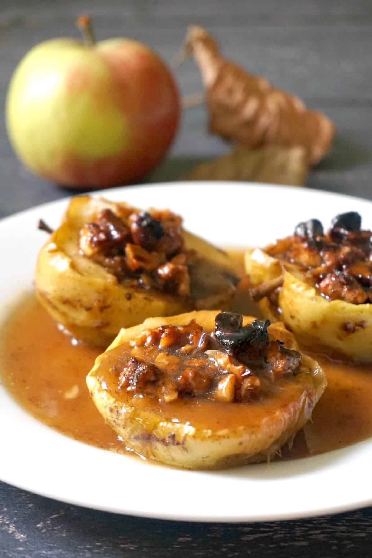 3 baked apple halves on a white plate.