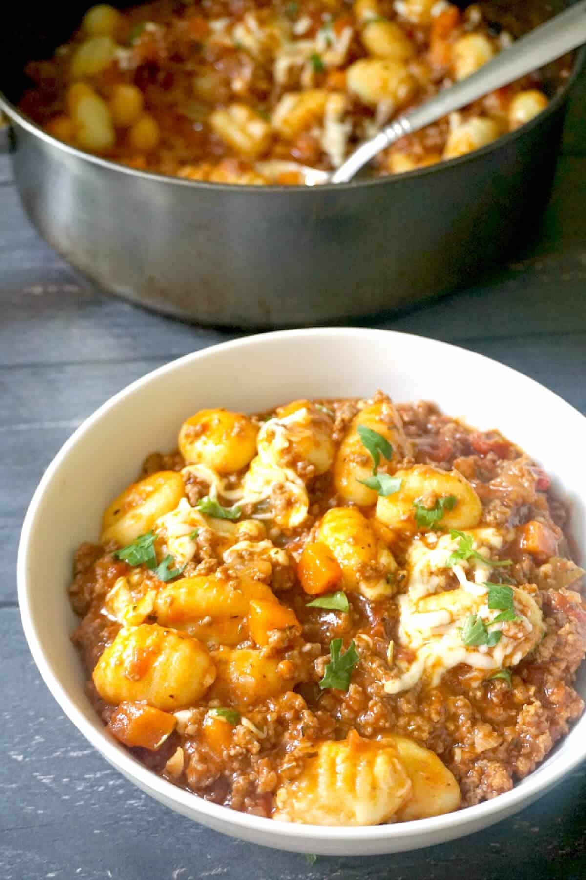 A white bowl with gnocchi bolognese.