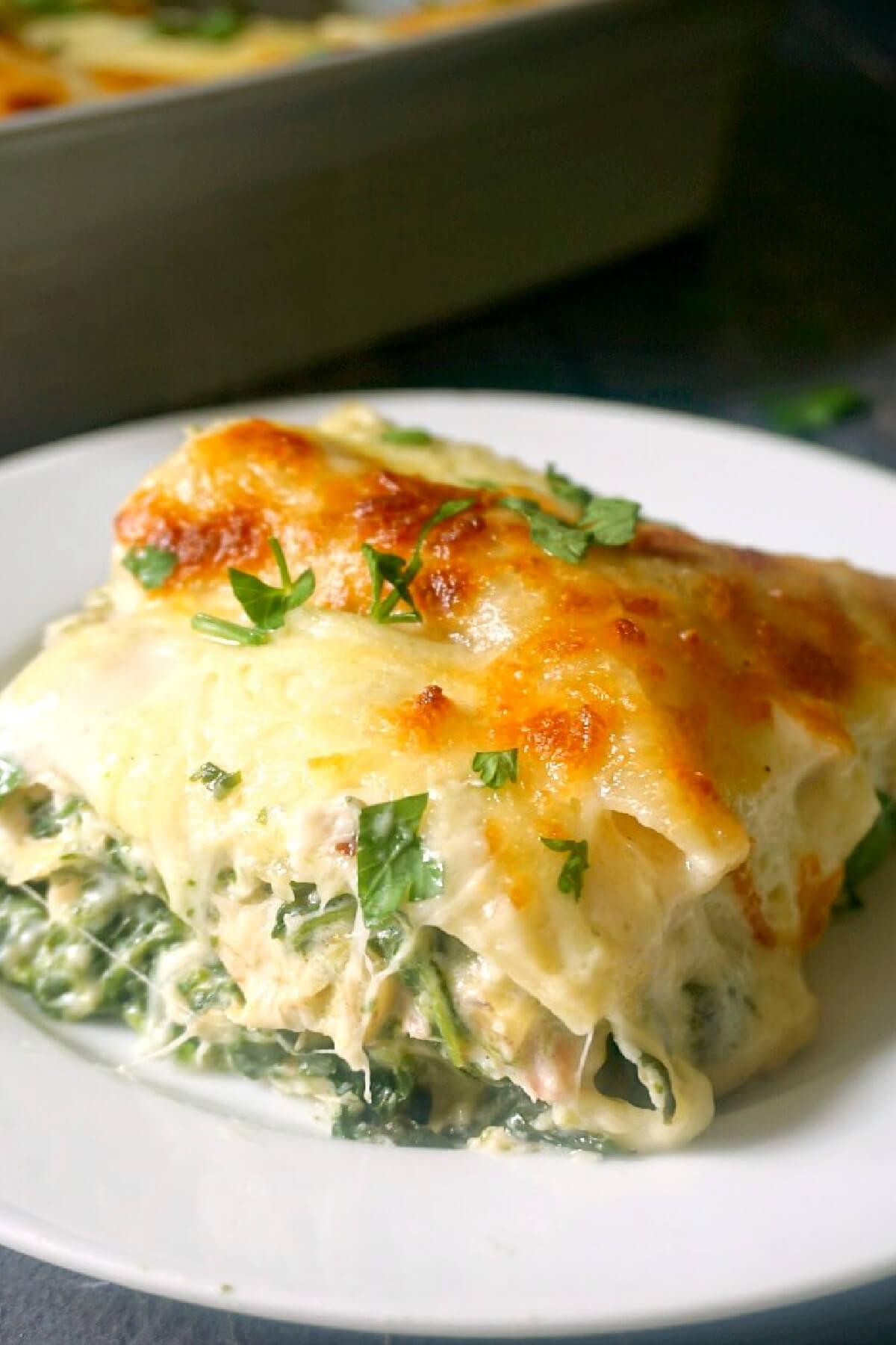 A portion of lasagna on a white plate.