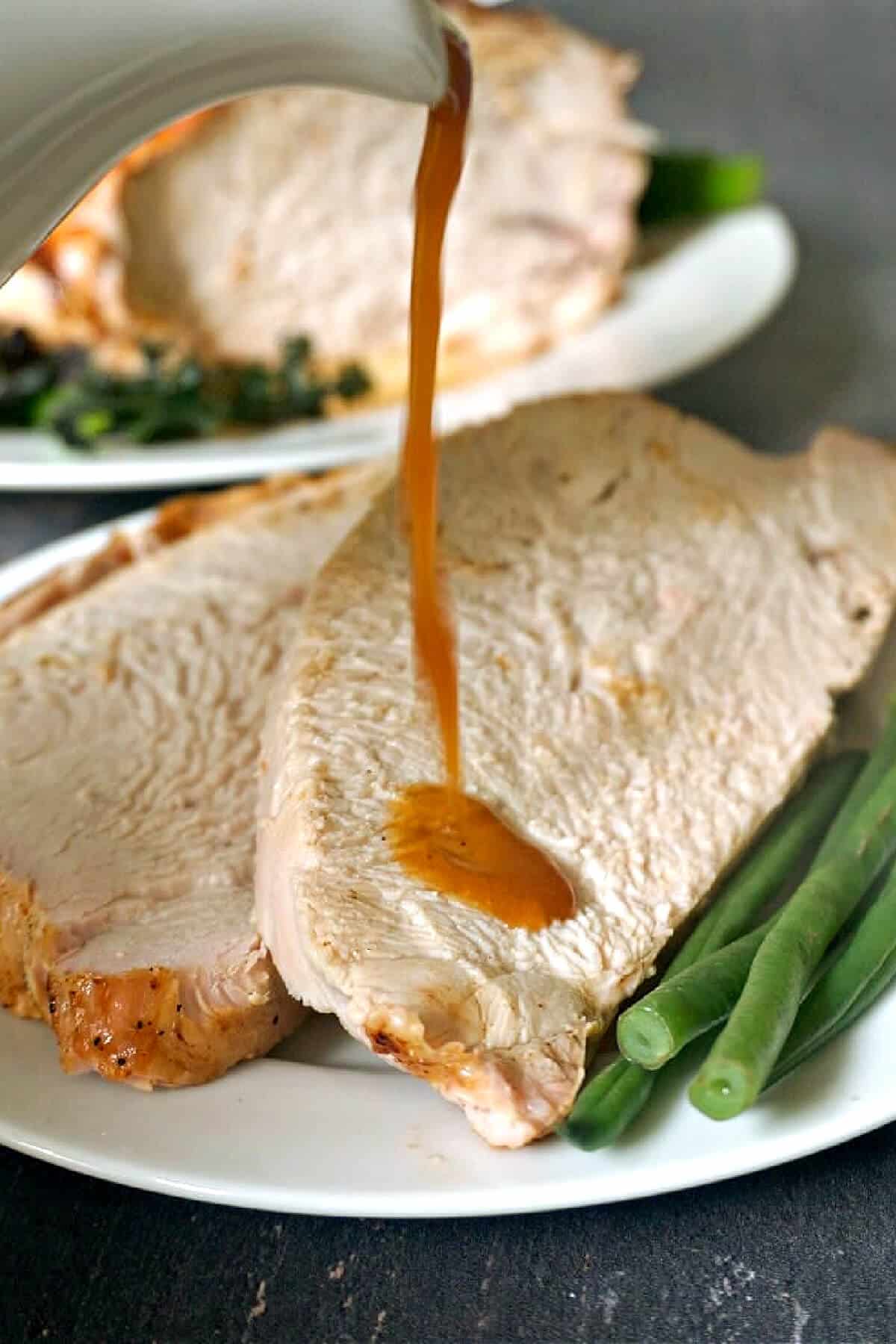 2 slices of turkey with gravy being drizzled over them.
