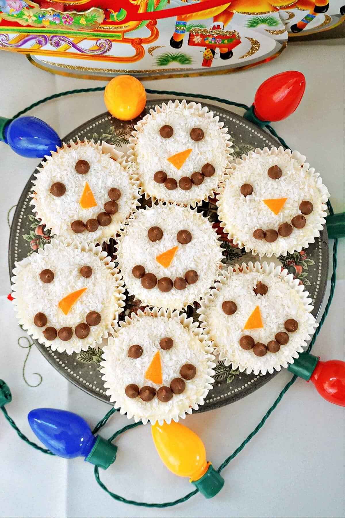 Overhead shoot of a plate with 7 snowman cupcakes.