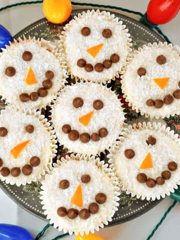 Overhead shoot of a plate with 7 snowman cupcakes