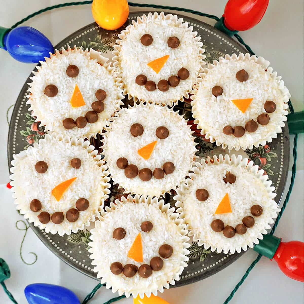 Overhead shoot of a plate with 7 snowman cupcakes