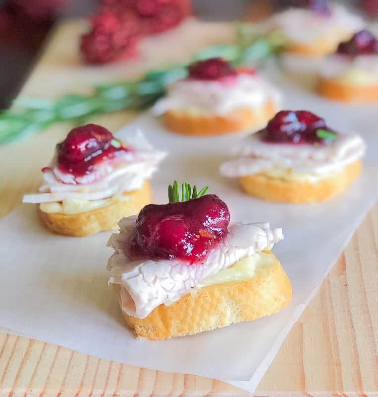 4 turkey crostini topped with cranberry sauce.