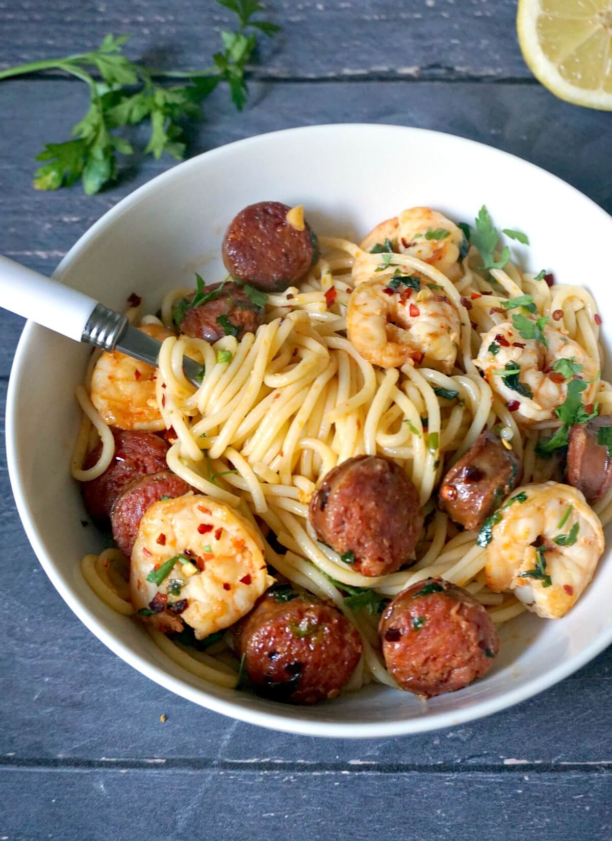 A bowl with pasta prawns and chorizo.