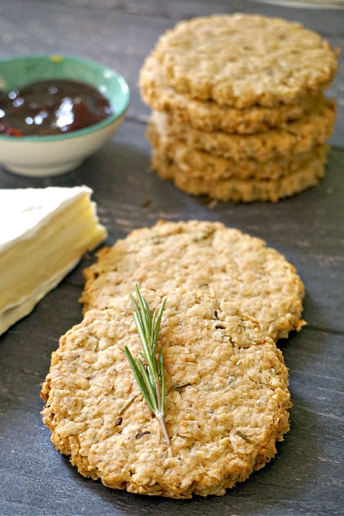 2 oat biscuits with a stack of more biscuits in the background.