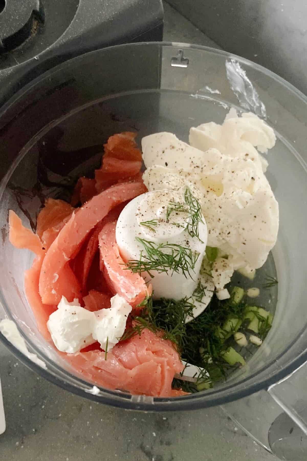 A blender with ingredients needed to make salmon pate.