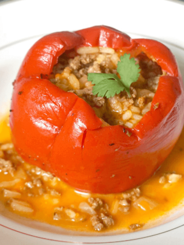 A white bowl with a red pepper stuffed with rice and ground beef