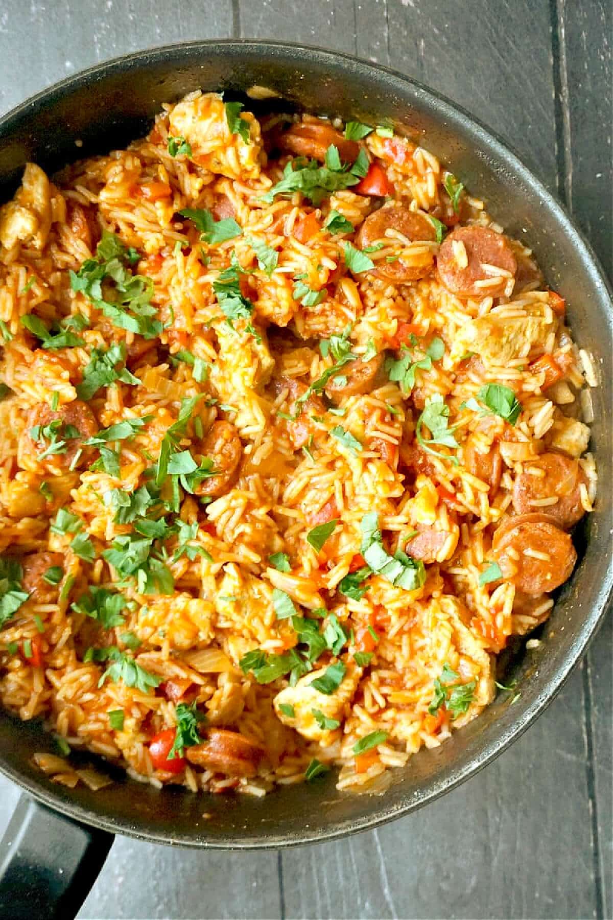 A pot with rice, chicken and chorizo.
