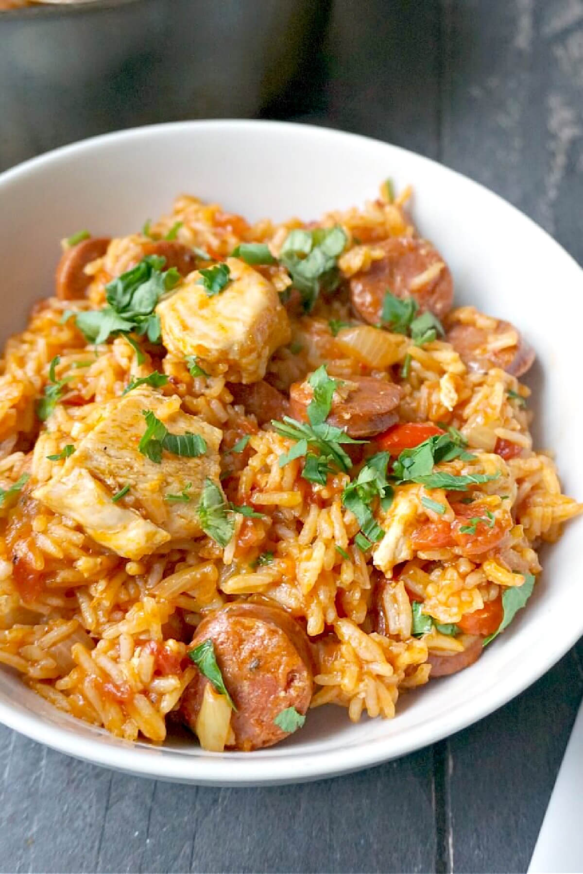 A white bowl with chicken and chorizo jamabalaya rice.