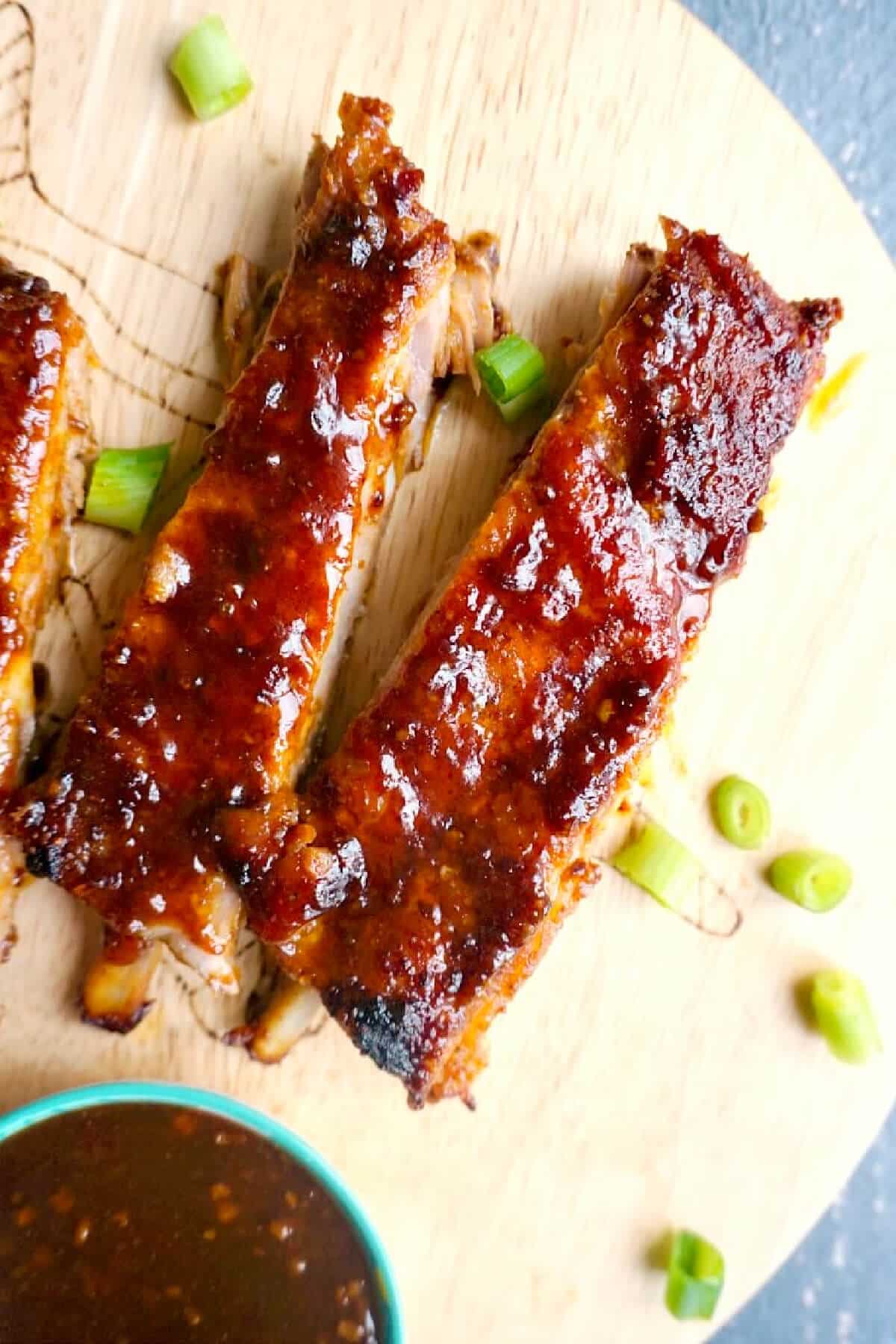 Overhead shoot of 2 pork ribs on a wooden board.