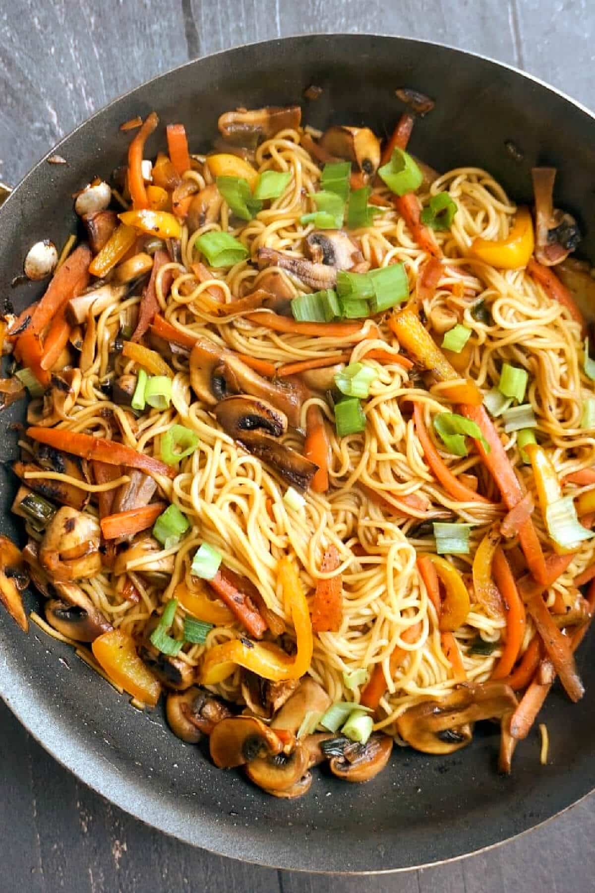 A pot with noodles and vegetable stir fry.