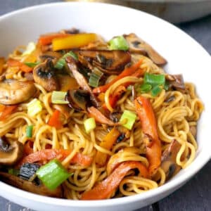 A white bowl with vegetable egg noodle stir fry