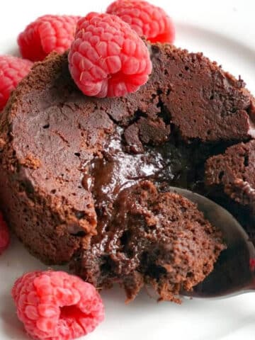 A molten chocolate cake surrounded by raspberries