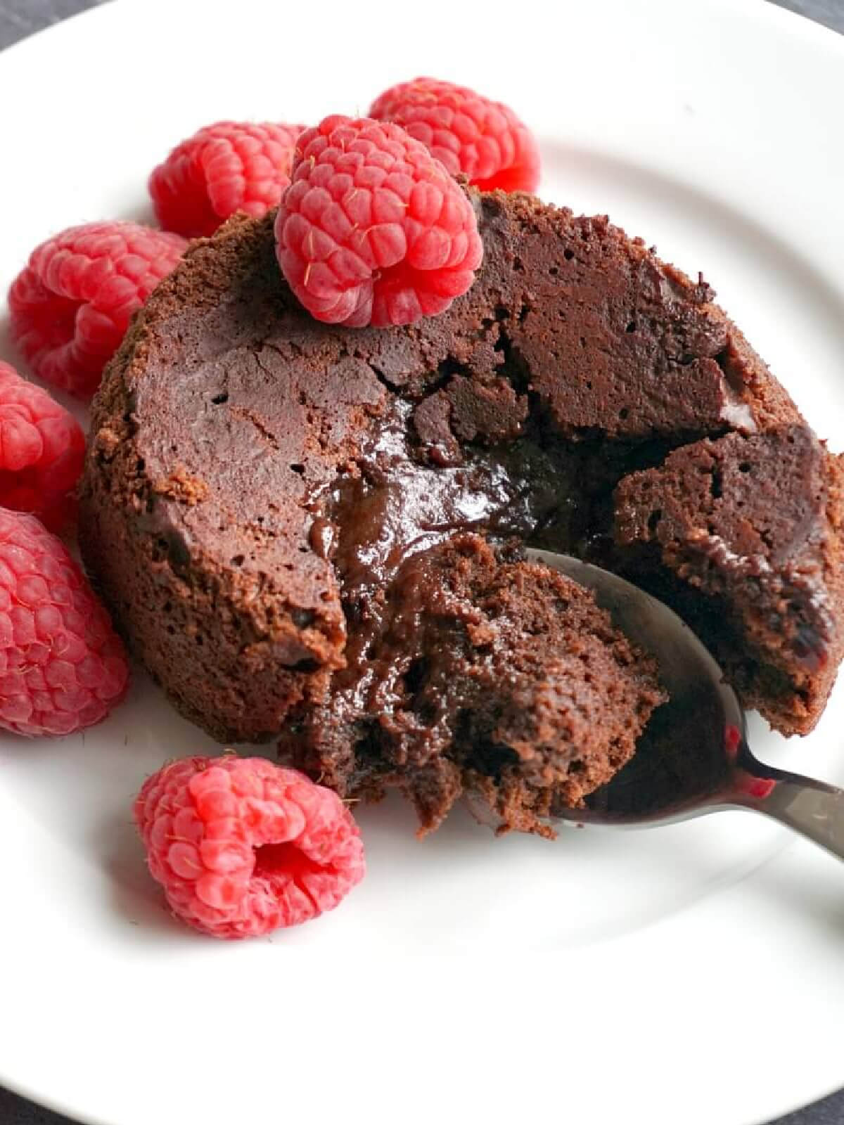 A chocolate lava cake topped with raspberries.