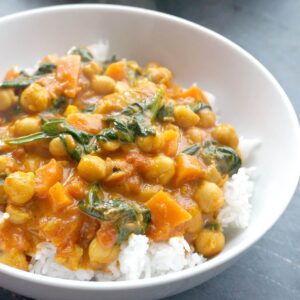 A white bowl with rice and coconut chickpea curry