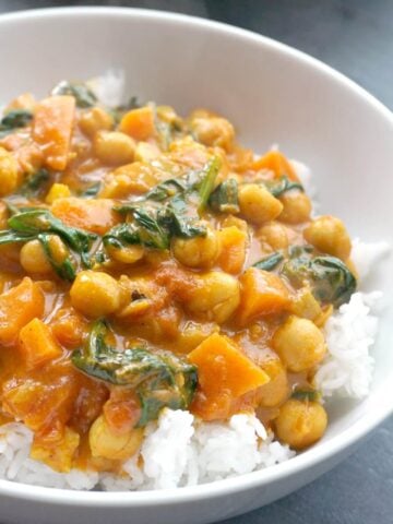 A white bowl with rice and coconut chickpea curry