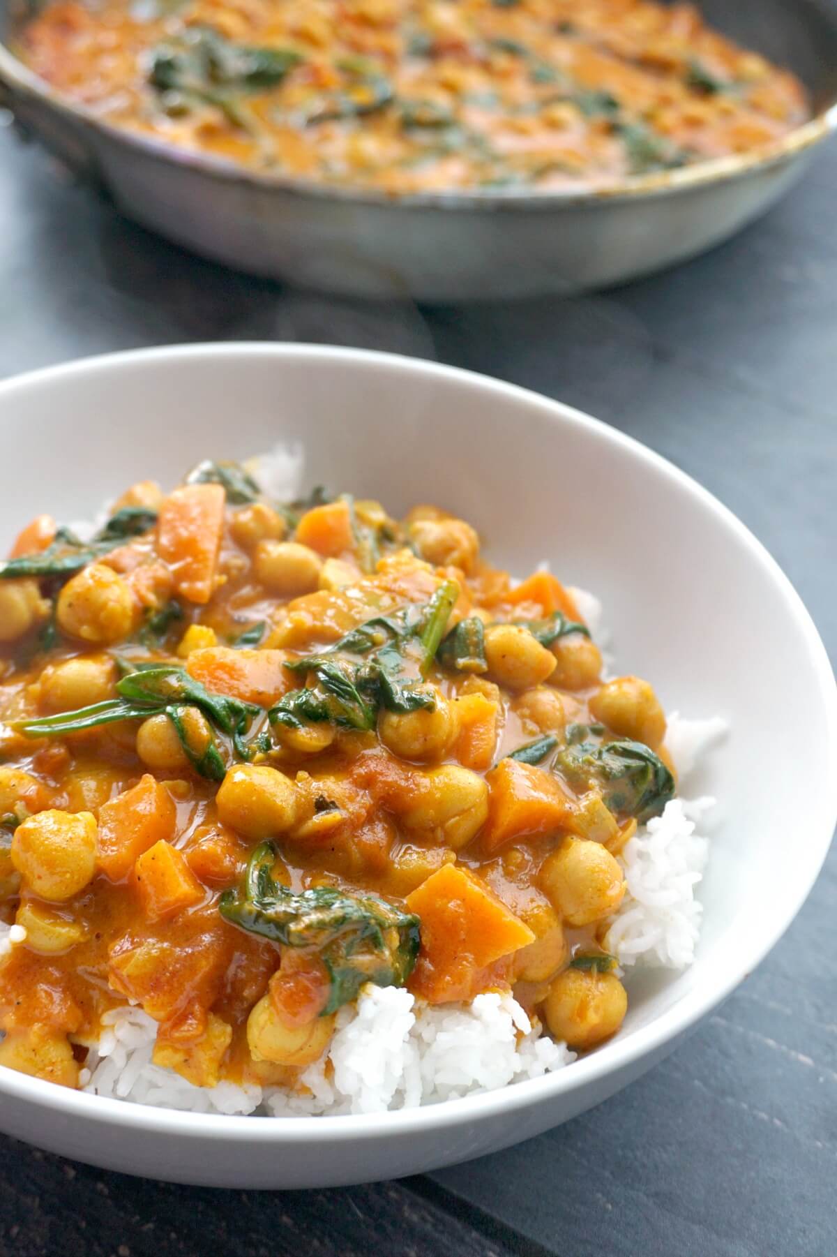 A white bowl with rice and chickpea curry.