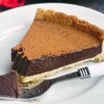 A slice of chocolate tart on a white plate