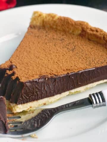 A slice of chocolate tart on a white plate