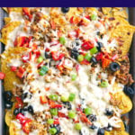 Overhead shot of nachos topped with ground pork, veggies and cheese