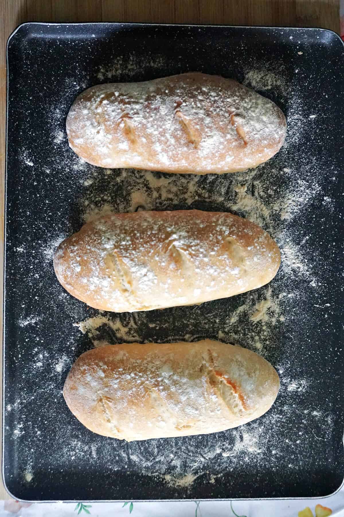 A baking tray with 3 bread loaves.