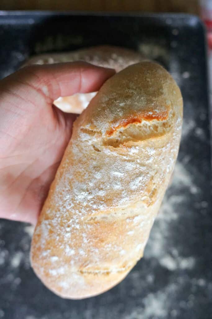 A hand holding a mini bread loaf.