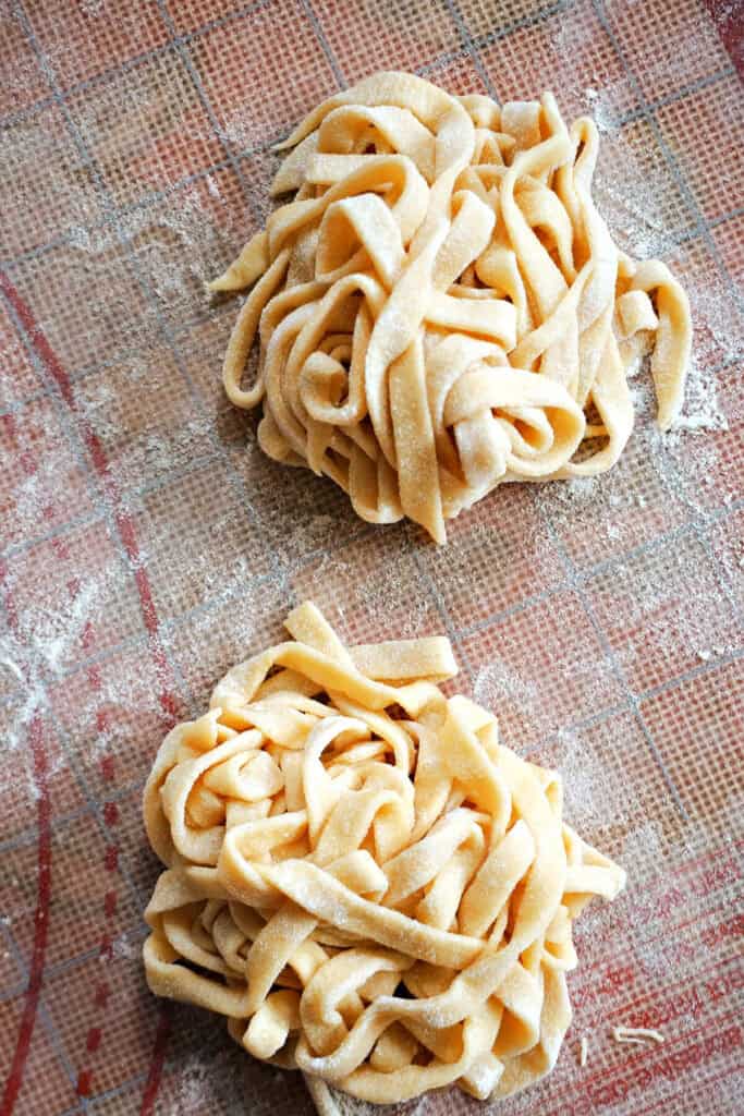 2 nests of fettuccine pasta on a tabletop.