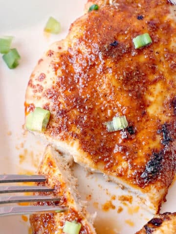 Close-up shoot of a white plate with chicken breast cut in half