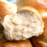Close-up shoot of half a bread roll on top of 4 other rolls