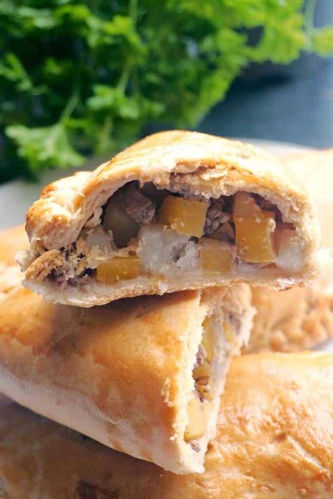 Half a beef pasty on top of other pasties