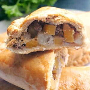 Half of a Cornish pasty on top of other pasties