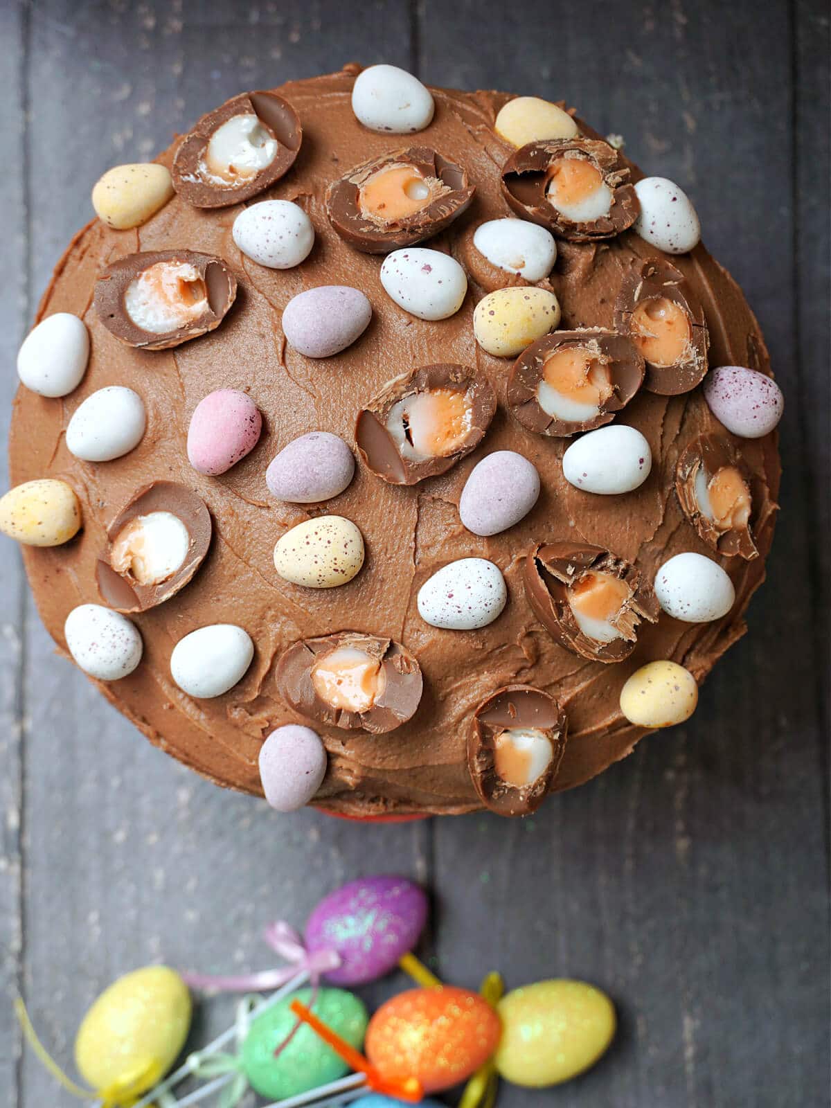 Overhead shoot of a chocolate cake topped with Easter eggs.