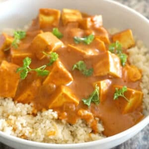 A white bowl with couscous and tofu curry