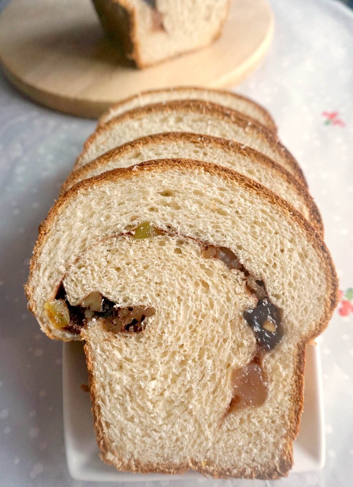 4 slices of cozonac on a white rectangle plate.