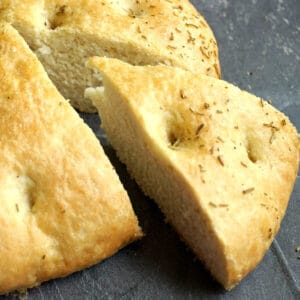A slice of focaccia bread cut out of the loaf