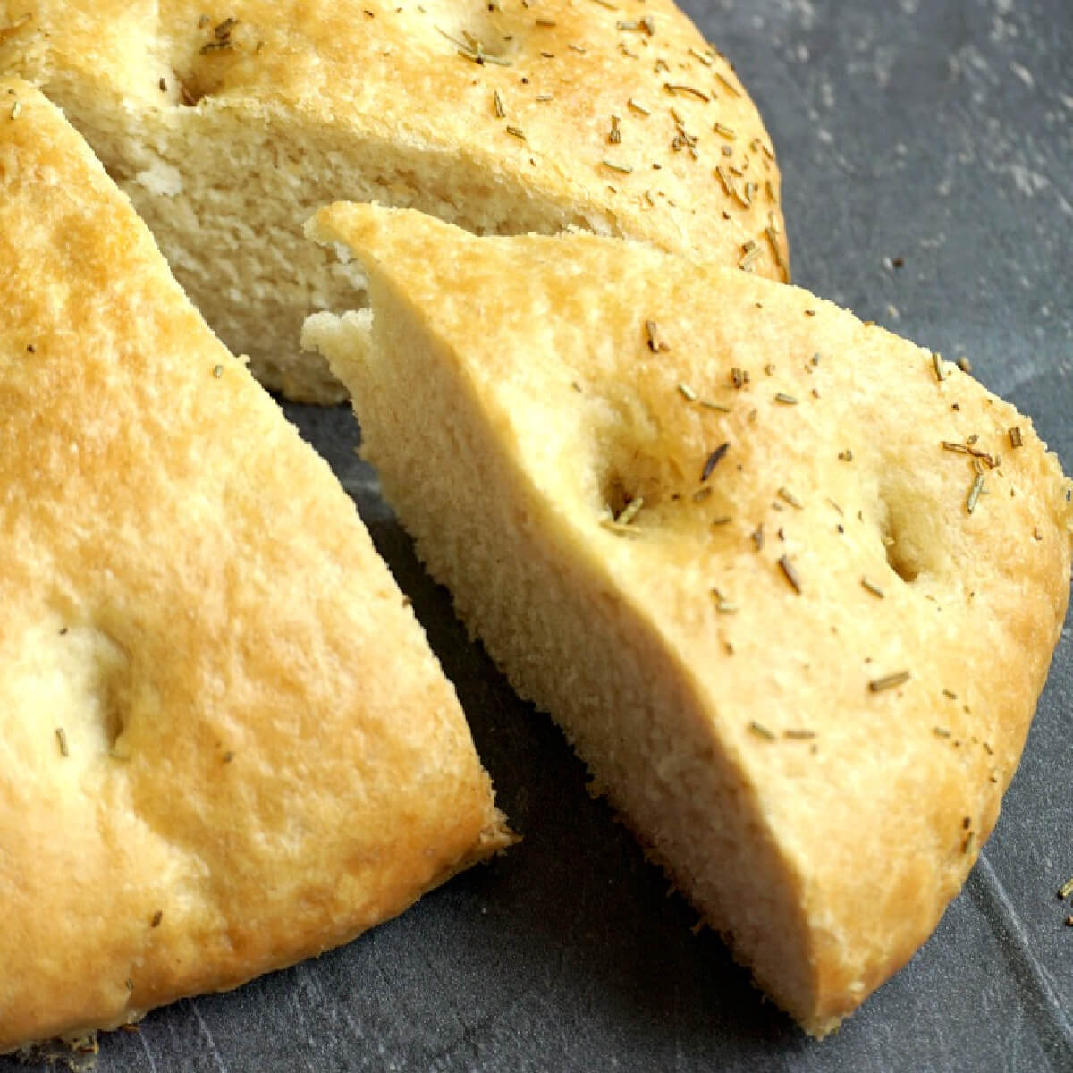 A slice of focaccia bread cut out of the loaf