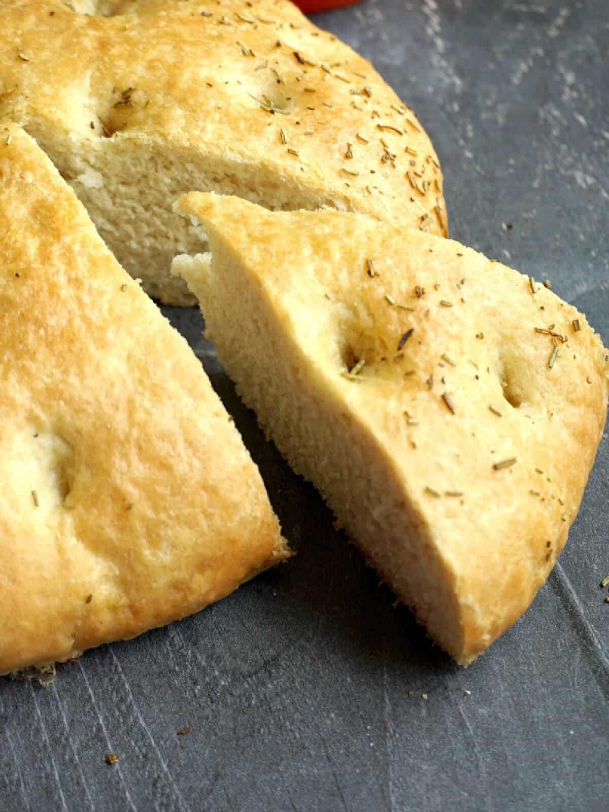 A slice of focaccia cut out of the loaf.