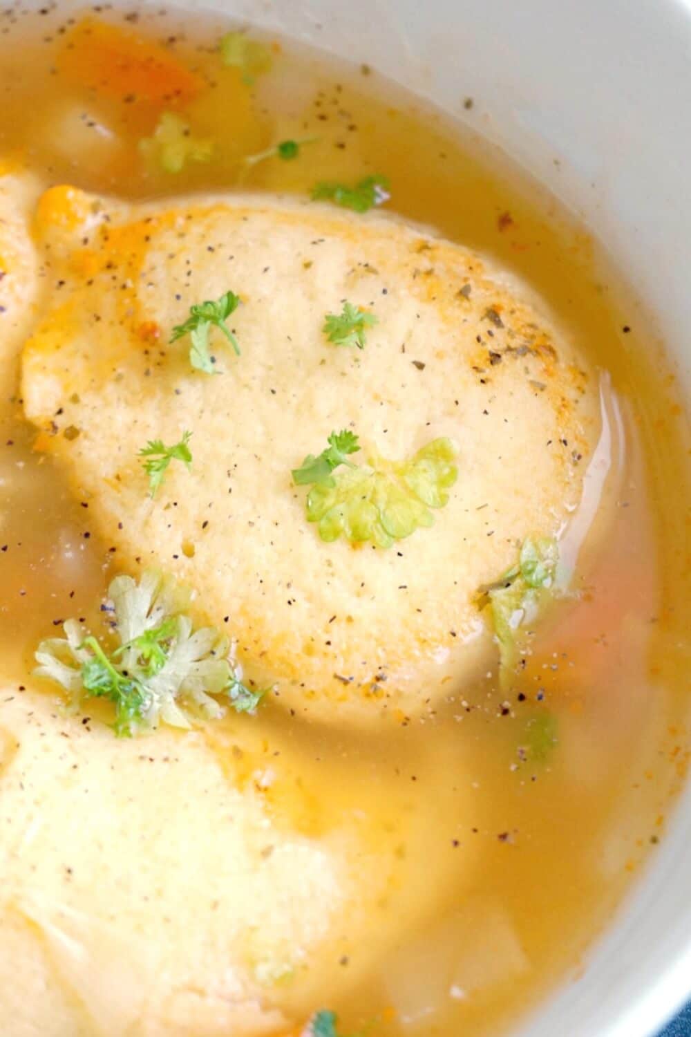 Close-up shoot of 2 semolina dumplings in a soup.