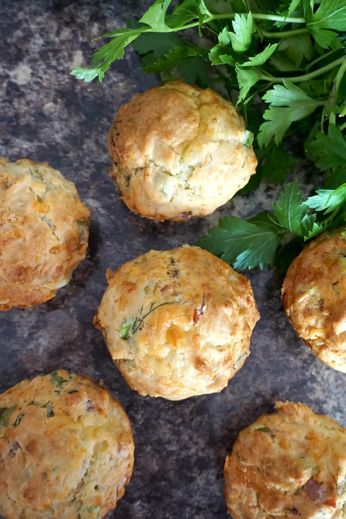 Overhead shoot of 6 muffins and fresh parsley.