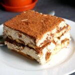 A white plate with a slice of dalgona tiramisu