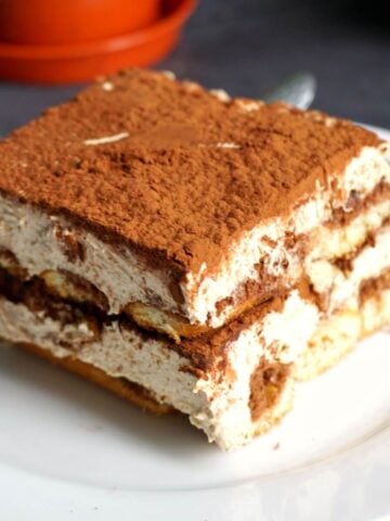 A white plate with a slice of dalgona tiramisu