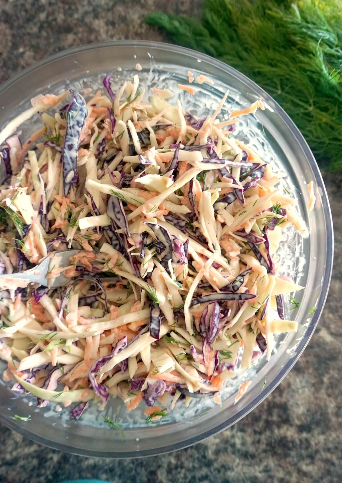 A glass bowl with dill coleslaw