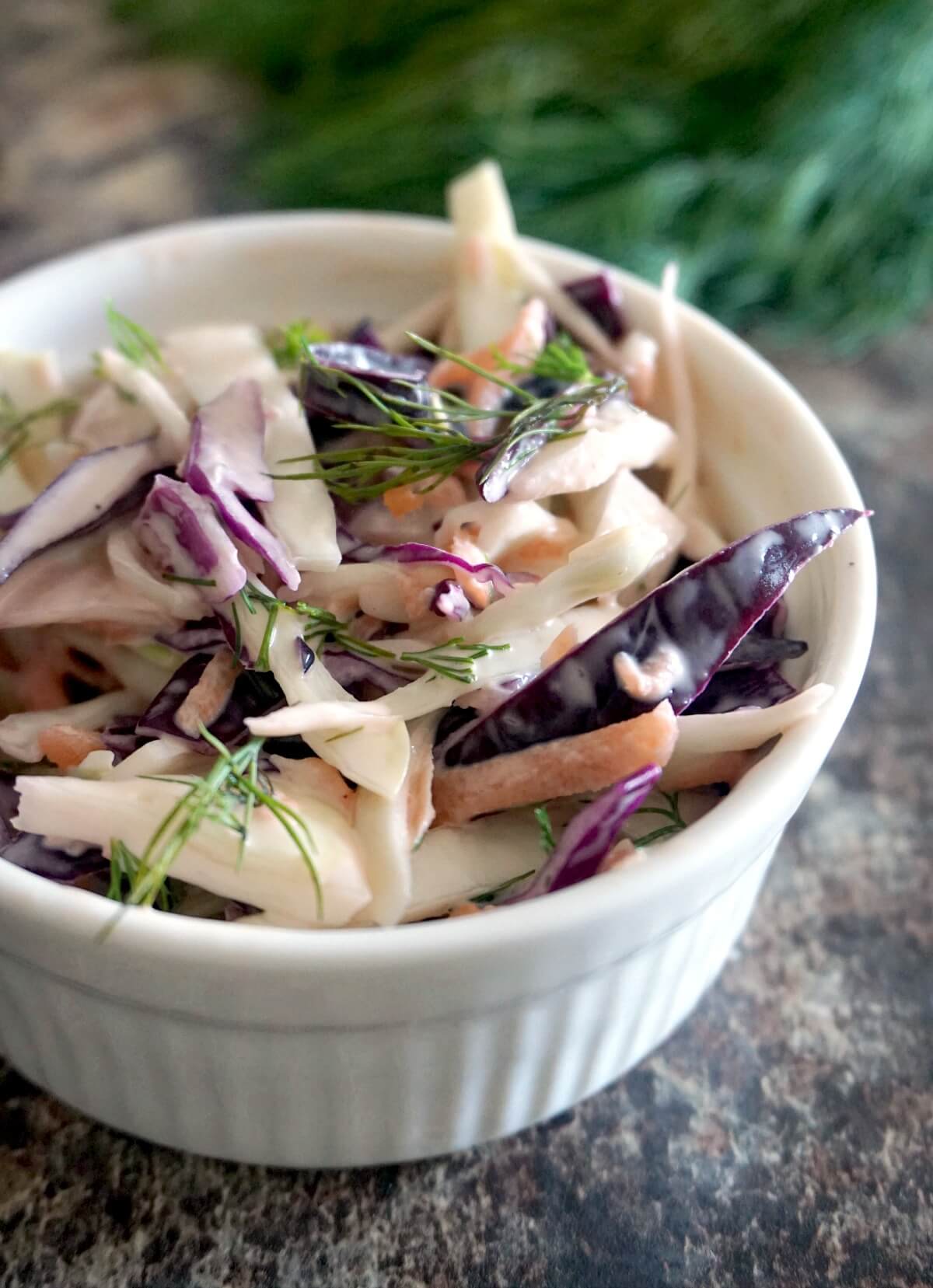 A white bowl with coleslaw.