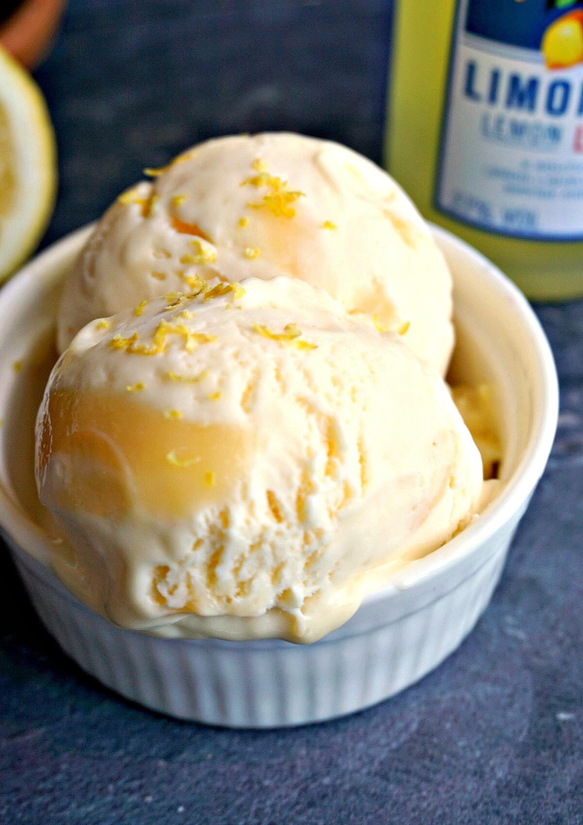 2 scoops of lemon curd ice cream in a white bowl.