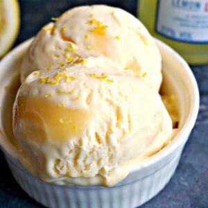 2 scoops of lemon curd and limoncello ice cream in a small white bowl