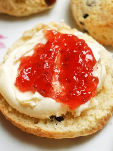 Half a scone topped with cream and jam