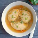 Overhead shoot of a white bowl of semolina dumpling soup