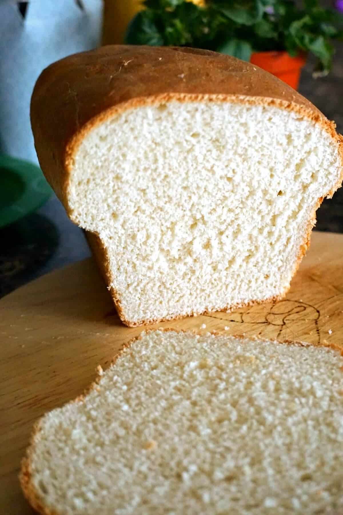 A sliced loaf of bread on a wooden board.