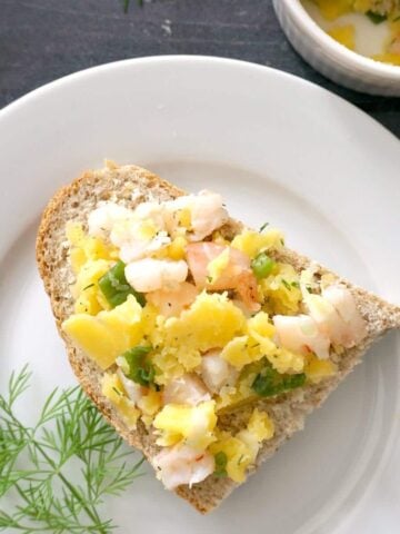 Overhead shoot of a white plate with a white ramekin with potted shrimp